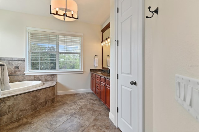 bathroom featuring a relaxing tiled tub, vanity, and a chandelier