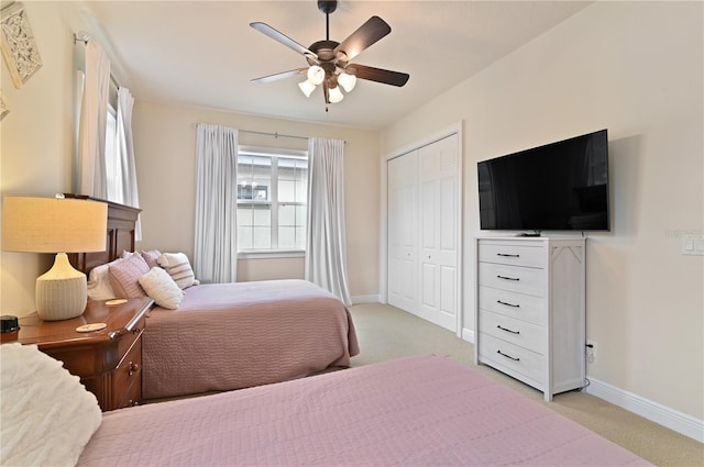 carpeted bedroom featuring ceiling fan and a closet