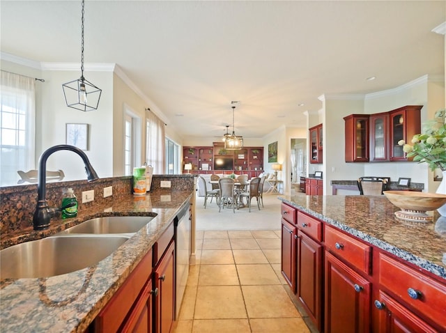 kitchen with dark stone countertops, dishwasher, hanging light fixtures, crown molding, and sink