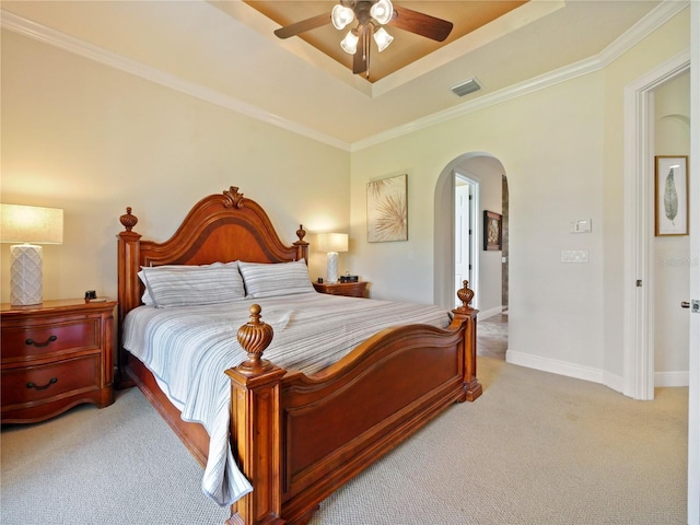 bedroom with ceiling fan, light carpet, ornamental molding, and a raised ceiling