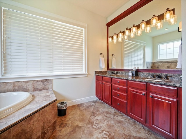 bathroom with tiled tub and vanity