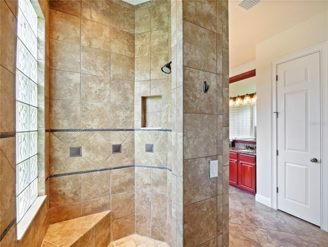 bathroom featuring a tile shower and vanity