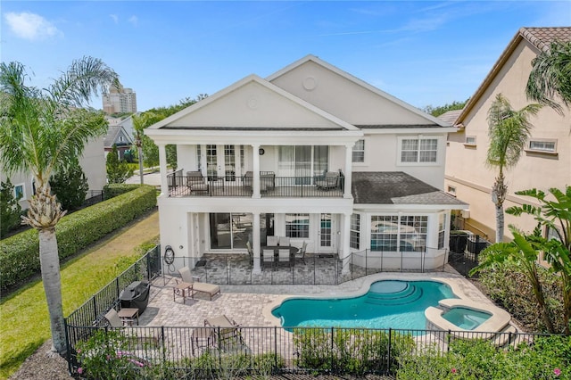 back of house featuring a patio area, a swimming pool with hot tub, and a balcony