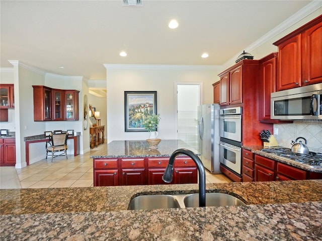 kitchen with sink, light tile patterned floors, ornamental molding, and stainless steel appliances