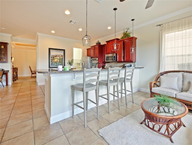 kitchen featuring kitchen peninsula, ceiling fan, stainless steel appliances, crown molding, and pendant lighting