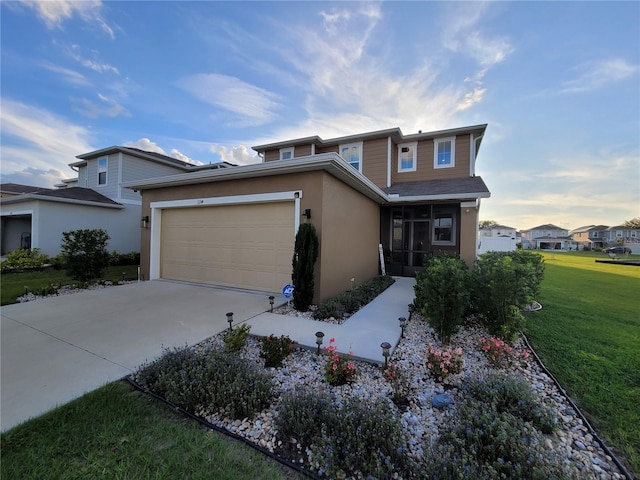 traditional-style home featuring a garage, a front yard, driveway, and stucco siding