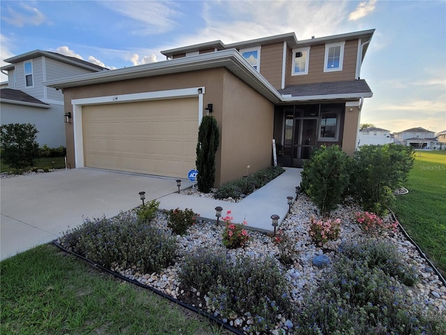 view of front of property with concrete driveway, a garage, a sunroom, and stucco siding