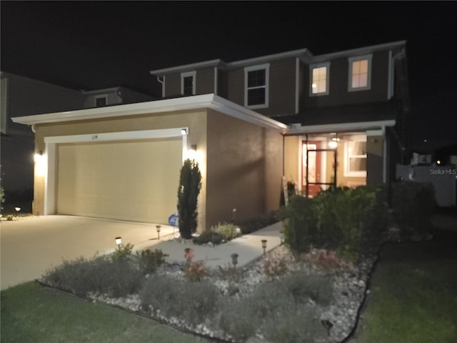 view of front of property featuring a garage, driveway, and stucco siding