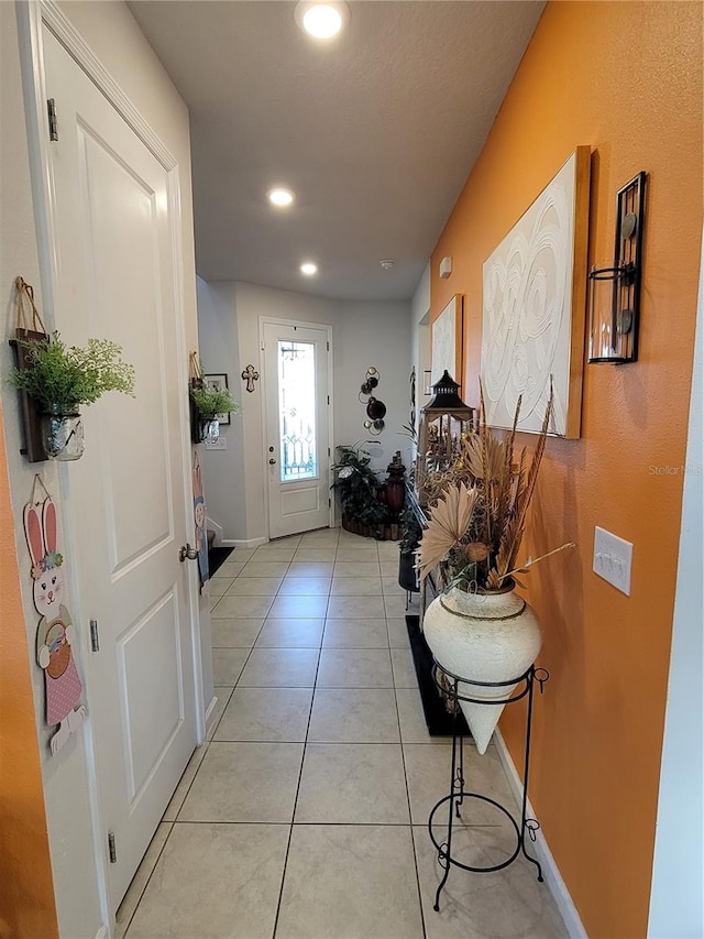 doorway to outside with light tile patterned floors, baseboards, and recessed lighting