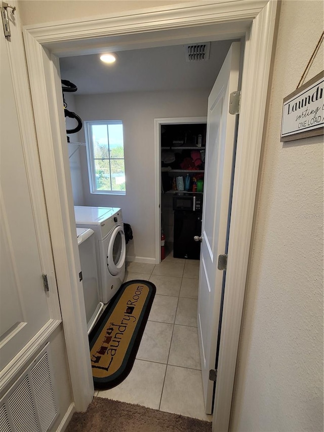 washroom with light tile patterned floors, laundry area, independent washer and dryer, and visible vents