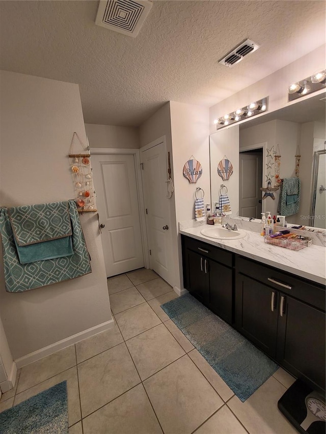 full bathroom with tile patterned floors, visible vents, a textured ceiling, and vanity