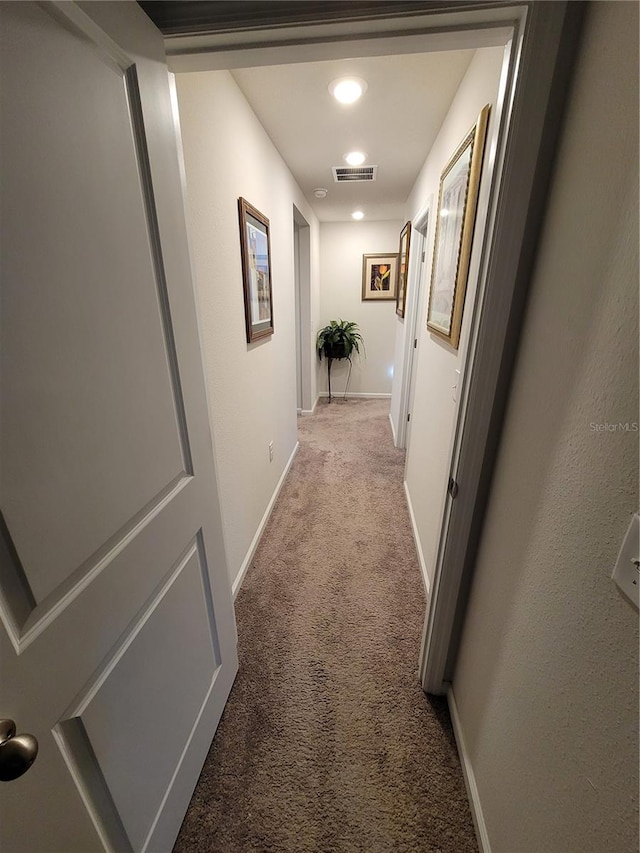 hallway with recessed lighting, visible vents, baseboards, and light colored carpet