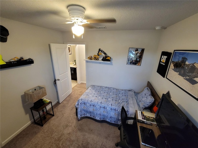 carpeted bedroom with visible vents, a ceiling fan, baseboards, and a textured ceiling