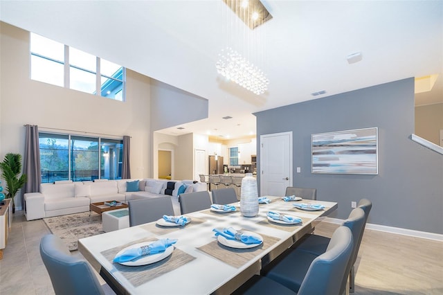 dining room with a towering ceiling and an inviting chandelier