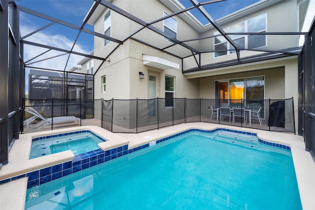 view of swimming pool featuring a patio area, an in ground hot tub, and glass enclosure