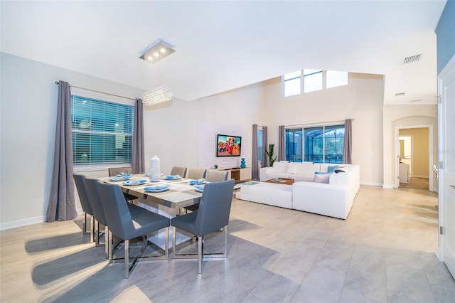 dining area with light tile flooring and a high ceiling