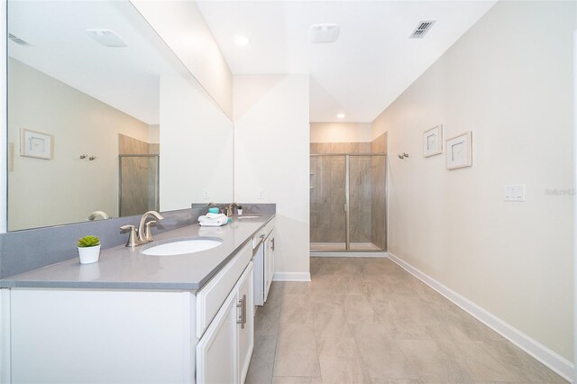 bathroom featuring double sink, walk in shower, tile flooring, and large vanity