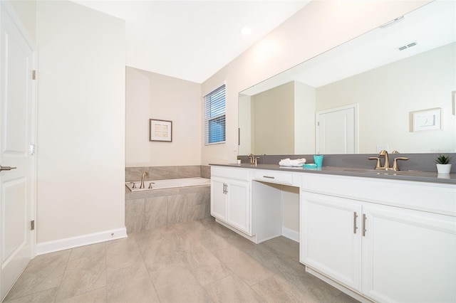 bathroom featuring double sink vanity, tile flooring, and tiled tub