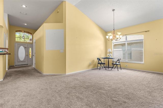 interior space featuring carpet flooring, an inviting chandelier, and high vaulted ceiling