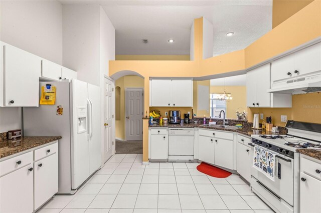 kitchen featuring a high ceiling, sink, white appliances, and white cabinetry