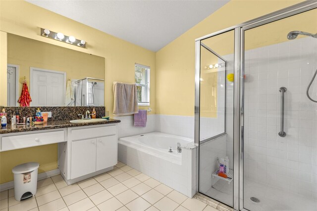 bathroom featuring vanity, vaulted ceiling, separate shower and tub, and tile patterned flooring