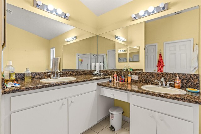 bathroom featuring tile patterned flooring, vanity, vaulted ceiling, and a shower with shower door