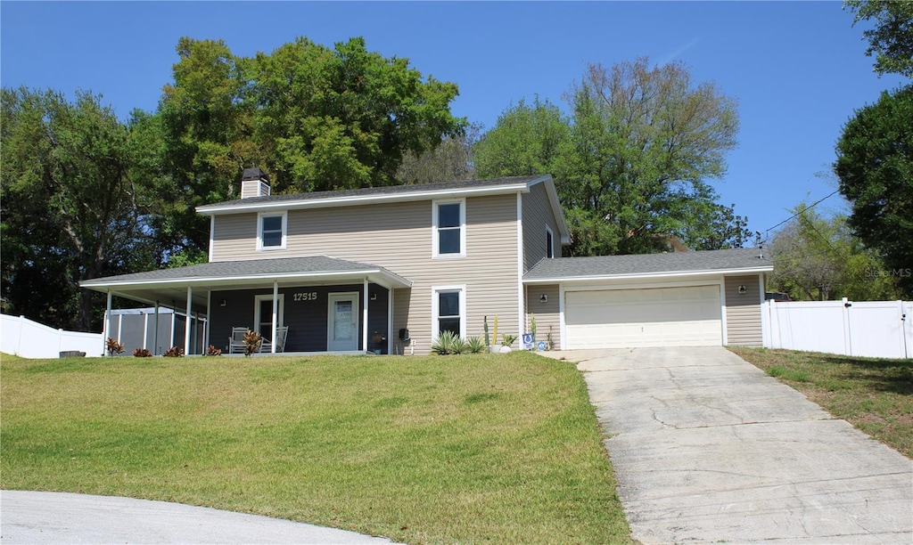 view of front of property featuring a front yard, a porch, and a garage