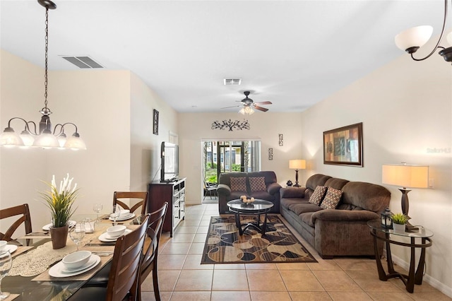 living room featuring light tile flooring and ceiling fan with notable chandelier