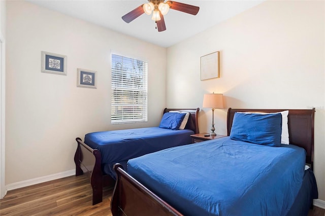 bedroom with dark hardwood / wood-style flooring and ceiling fan