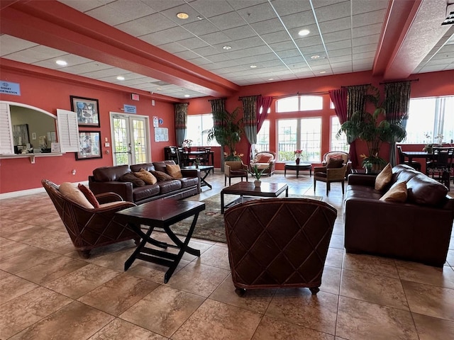 tiled living room featuring a paneled ceiling, french doors, a healthy amount of sunlight, and beamed ceiling