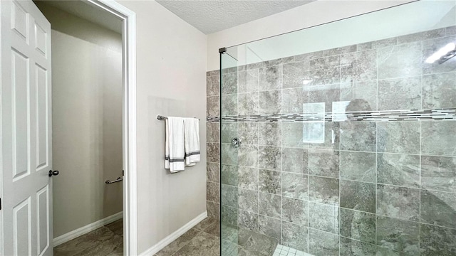 bathroom featuring a textured ceiling, tile floors, and a tile shower