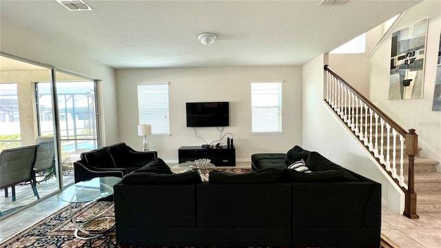 tiled living room featuring plenty of natural light and a textured ceiling