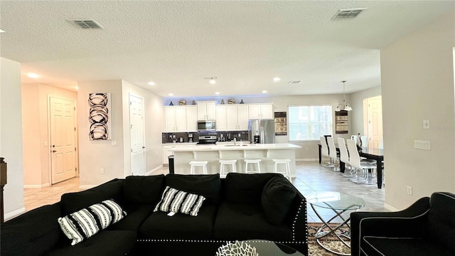 tiled living room featuring a textured ceiling