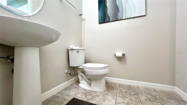 bathroom featuring tile flooring and toilet