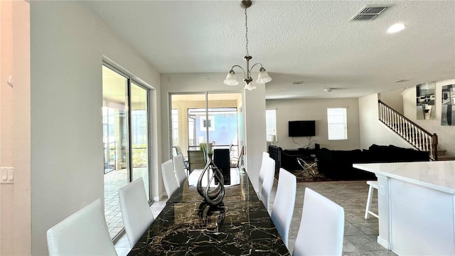 interior space featuring a notable chandelier, plenty of natural light, and a textured ceiling