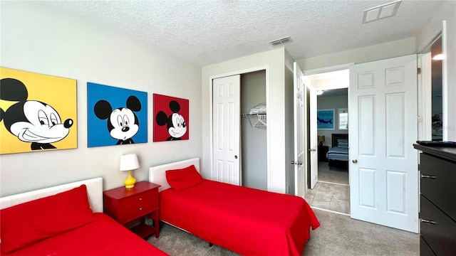 bedroom featuring a closet, a textured ceiling, and dark carpet