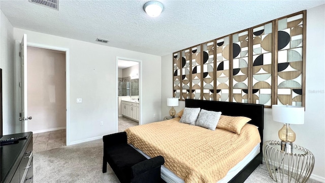 carpeted bedroom featuring a textured ceiling and connected bathroom