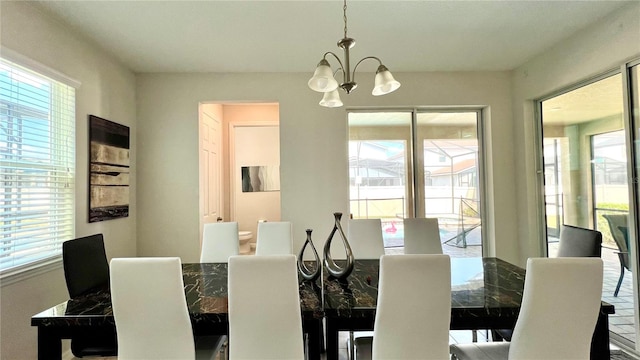 dining area featuring plenty of natural light and an inviting chandelier