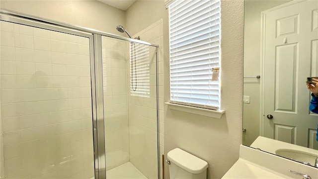 bathroom with an enclosed shower, vanity, and toilet