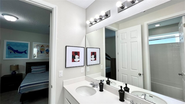 bathroom with a textured ceiling, vanity, and shower / bathtub combination