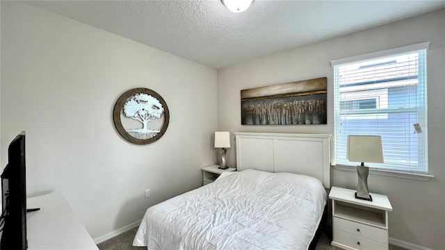 bedroom featuring carpet flooring and a textured ceiling