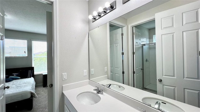 bathroom featuring dual bowl vanity and a textured ceiling