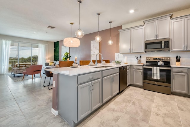 kitchen with pendant lighting, gray cabinetry, sink, and stainless steel appliances