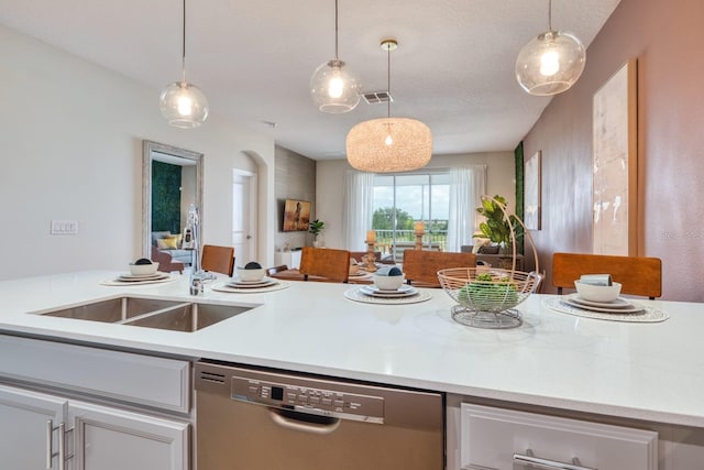 kitchen featuring white cabinets, hanging light fixtures, and stainless steel dishwasher