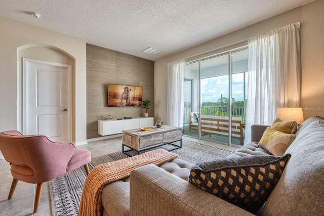 living room featuring light tile floors and a textured ceiling