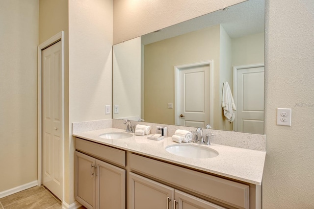 bathroom with dual bowl vanity and tile flooring