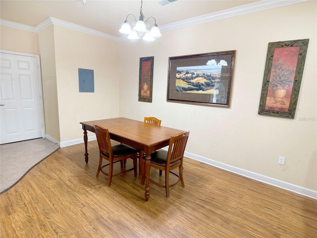 dining room with light hardwood / wood-style floors, an inviting chandelier, and crown molding