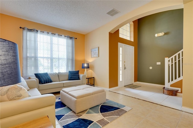 tiled living room featuring a textured ceiling