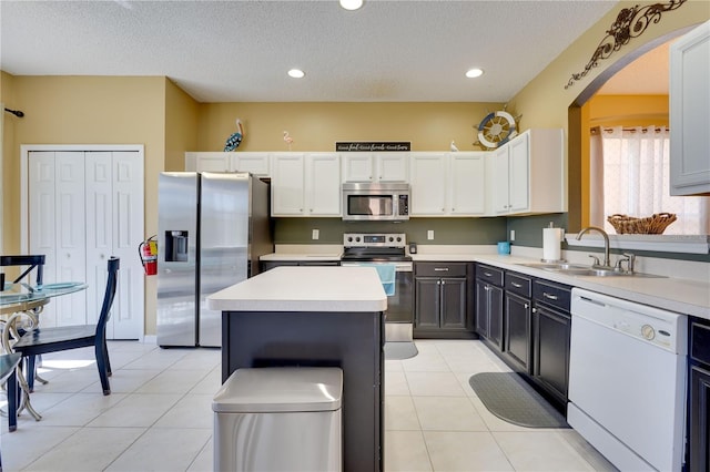 kitchen with sink, stainless steel appliances, white cabinets, and a kitchen island