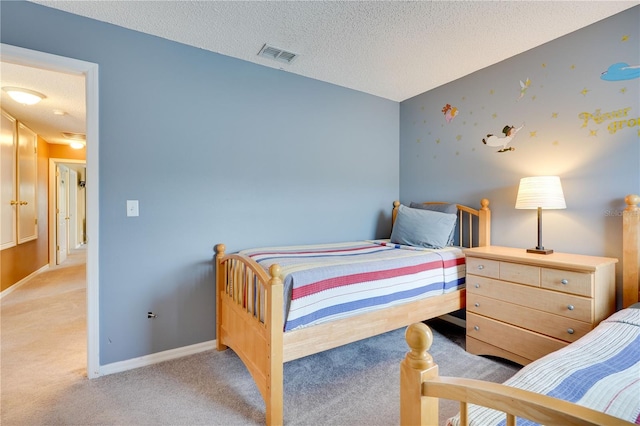 bedroom featuring light colored carpet and a textured ceiling